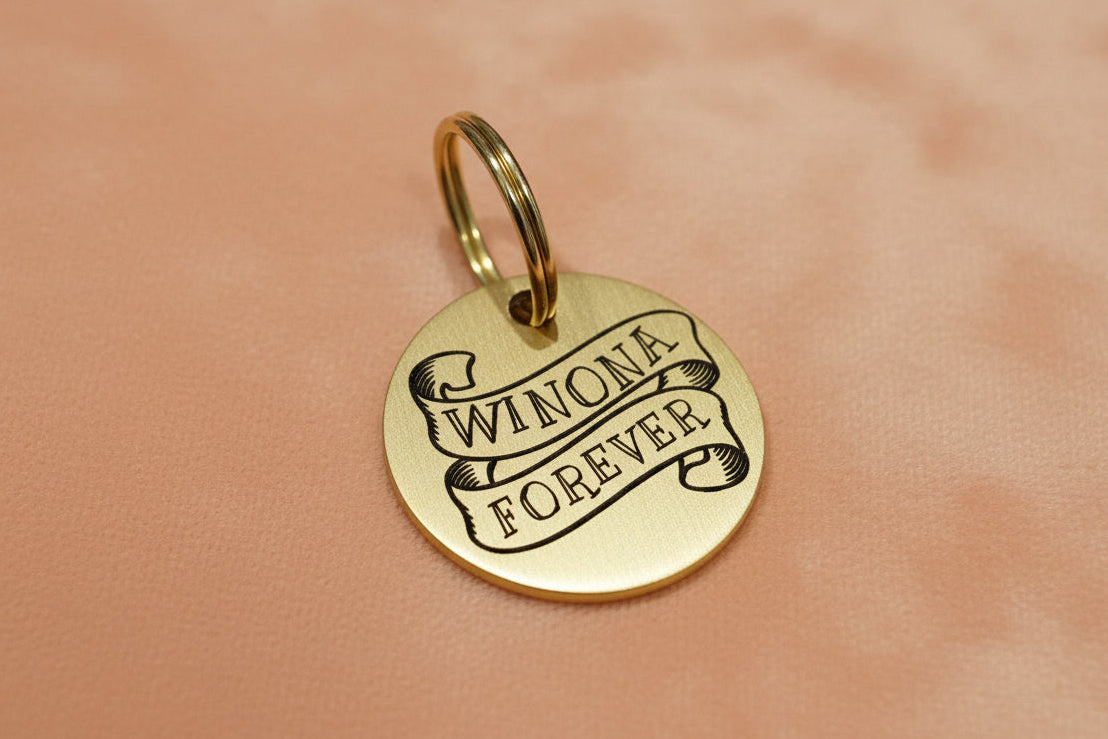 Gold dog tag with name engraved in a ribbon 