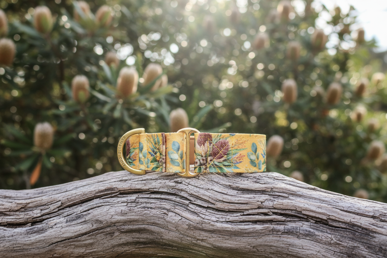 yellow martingale dog collar with floral design on a wooden log against a blurred natural background